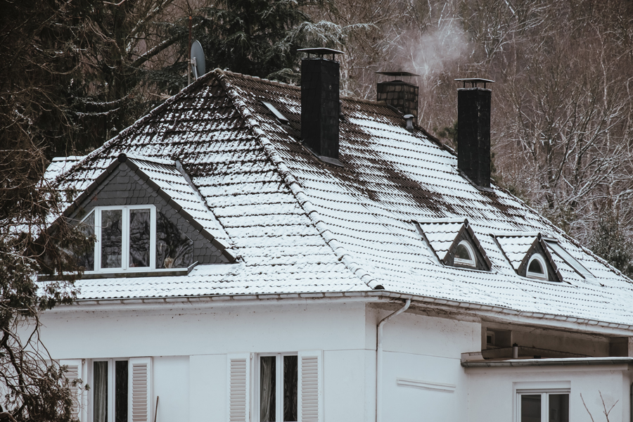 Big House With The Roof Covered By Snow In Winter